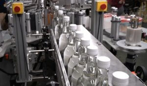 Improve Distillery Efficiency with Automated Packaging Solutions. Automatic Pressure Sensitive Labeler pictured.